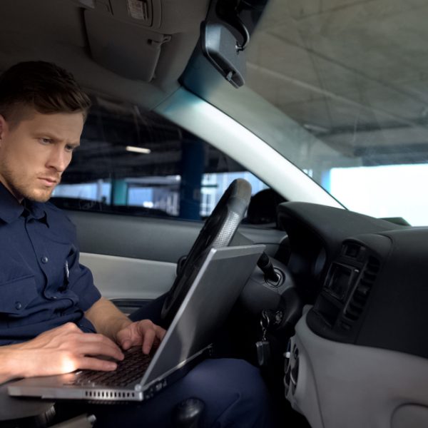 Male,Police,Officer,Working,On,Laptop,In,Car,,Filling,Data