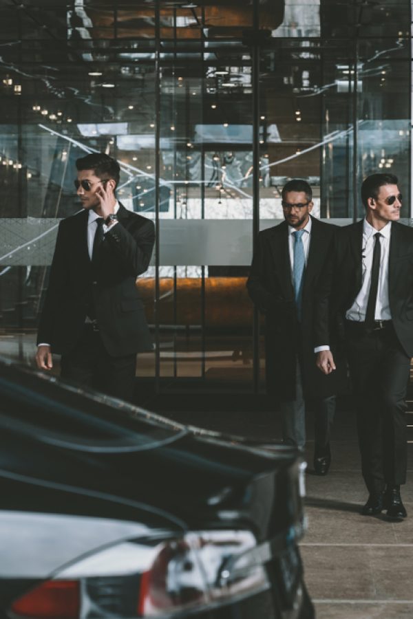 Businessman,And,Two,Bodyguards,Walking,To,Auto